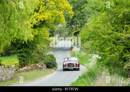 Automobilista la guida 1961 British realizzato Alvis TD21 serie DHC 1 drophead ooupe classic car sul paese lane in Cotswolds, Inghilterra Foto Stock