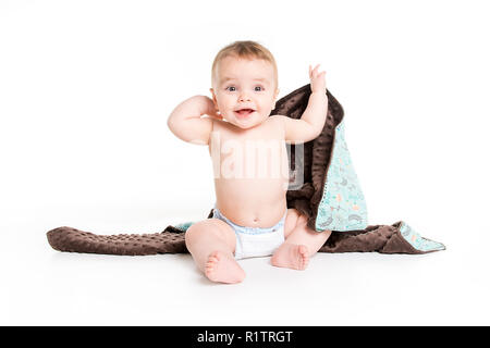 Il bambino sotto un asciugamano. Età di dieci mesi. Esso è isolato su sfondo bianco Foto Stock