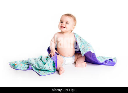 Il bambino sotto un asciugamano. Età di dieci mesi. Esso è isolato su sfondo bianco Foto Stock