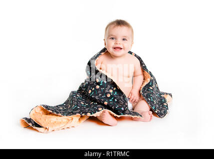 Il bambino sotto un asciugamano. Età di dieci mesi. Esso è isolato su sfondo bianco Foto Stock