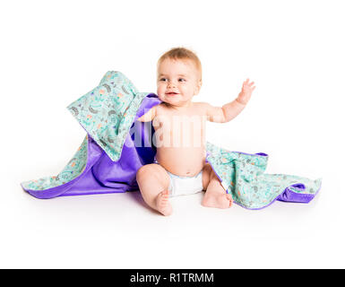 Il bambino sotto un asciugamano. Età di dieci mesi. Esso è isolato su sfondo bianco Foto Stock