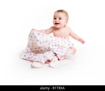 Il bambino sotto un asciugamano. Età di dieci mesi. Esso è isolato su sfondo bianco Foto Stock