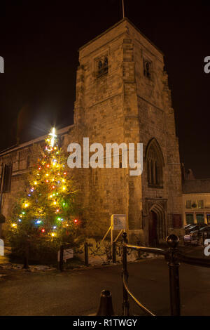St Michaels chiesa parrocchiale a Malton, North Yorkshire a Natale con un albero illuminato fuori dalla chiesa Foto Stock