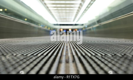 Il livello del terreno vista di un vuoto di tapis roulant in un aeroporto; scomparendo punto focale; tapis roulants, skywalk, escalator orizzontale; persone trasportatore. Foto Stock