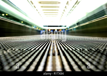 Il livello del terreno vista di un vuoto di tapis roulant in un aeroporto; scomparendo punto focale; tapis roulants, skywalk, escalator orizzontale; persone trasportatore. Foto Stock