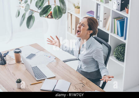 Angolo di alta vista ha sottolineato imprenditrice urlando al luogo di lavoro Foto Stock