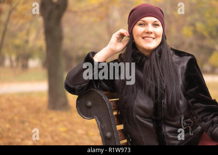 Donna Autunno in autunno park con ombrellone rosso, sciarpa e guanti in pelle Foto Stock