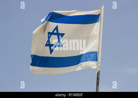 Un vestito di stracci Flage israeliano aloft in una brezza tesa contro un cielo blu al Banais Riserva Naturale delle alture del Golan in Israele. Foto Stock