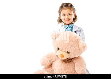 Bambino vestito di medici mantello bianco azienda big Teddy bear isolato su bianco Foto Stock