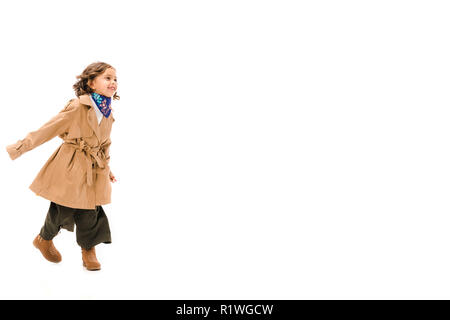 Splendido piccolo bambino in trench coat isolato in esecuzione su bianco Foto Stock