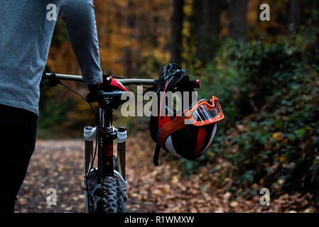 L'uomo spinge la sua mountain bike attraverso una foresta Foto Stock