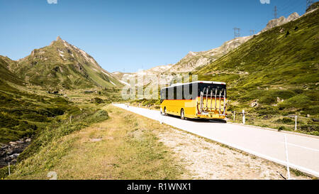 I mezzi di trasporto pubblici nelle montagne della Svizzera denominato autopostale. Autobus gialli sulla strada. Foto Stock