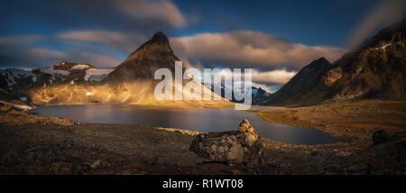 Kyrkja montagna al lago Kyrkjetjonne nella luce di sunrise, Jotunheimen, Norvegia Foto Stock