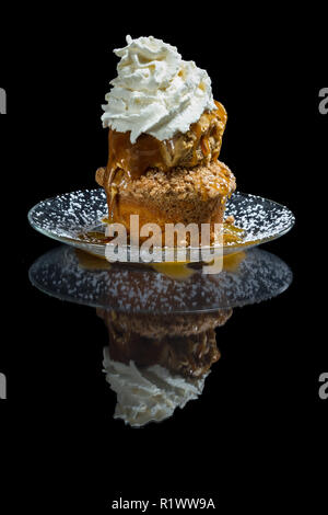 Dessert stratificato costituito da una torta di mele e rabboccato con caramello salato gelato e un ciuffo di panna montata Foto Stock