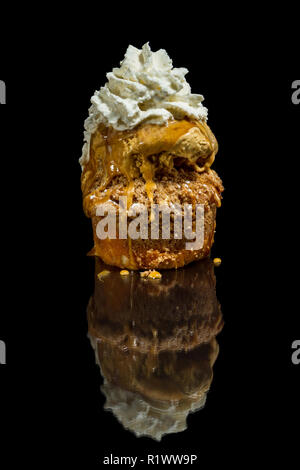 Dessert stratificato costituito da una torta di mele e rabboccato con caramello salato gelato e un ciuffo di panna montata Foto Stock