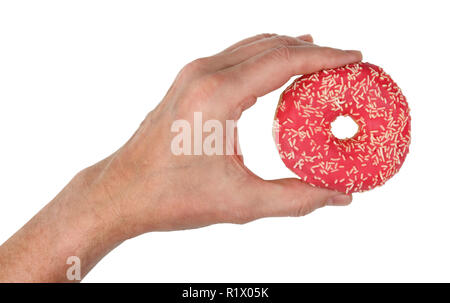 Il vecchio uomo di mano trattiene un rosa tenue ciambella con Glassa alla fragola. Isolato su bianco studio closeup Foto Stock