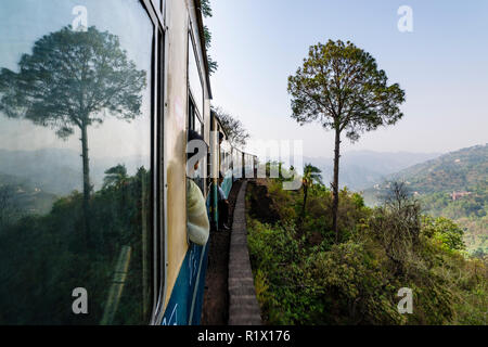 Un albero è il mirroring in una finestra del Toy Train, che sta lentamente il suo avvolgimento in modo da Kalpa di Shimla Foto Stock