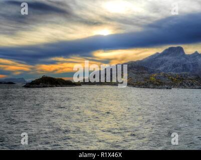 Piccola isola della costa norvegese sotto un cielo strano, Norvegia Foto Stock