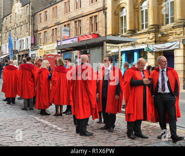 Dimostranti in rosso camici accademico sulla Sella del marchigiano, Edimburgo, Scozia Foto Stock