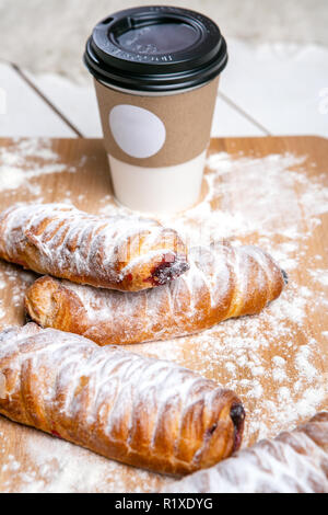 Tazza di caffè caldo con torte sul tavolo di legno su sfondo bianco. Colazione veloce. Cucina francese. Buona mattina. Foto Stock