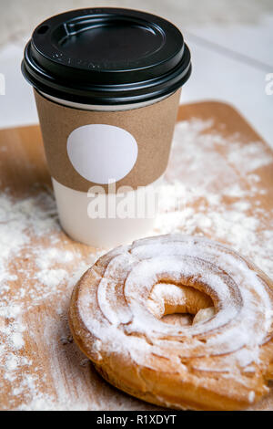 Tazza di caffè caldo con choux torta sul tavolo di legno su sfondo bianco. Colazione veloce. Cucina francese. Buona mattina. Foto Stock