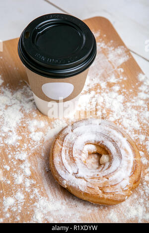 Tazza di caffè caldo con choux torta sul tavolo di legno su sfondo bianco. Colazione veloce. Cucina francese. Buona mattina. Foto Stock