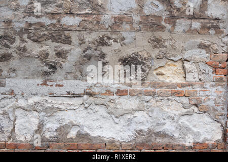 Close up weathered vecchio muro costruito di materiale misto di mattoni e pietra Foto Stock