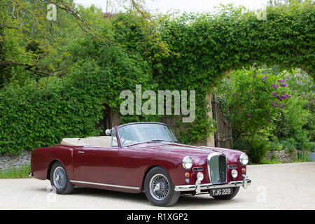 British realizzato Alvis TD21 serie DHC 1 drophead coupe auto classica - colore peonia - parcheggiata in Cotswolds, Inghilterra Foto Stock