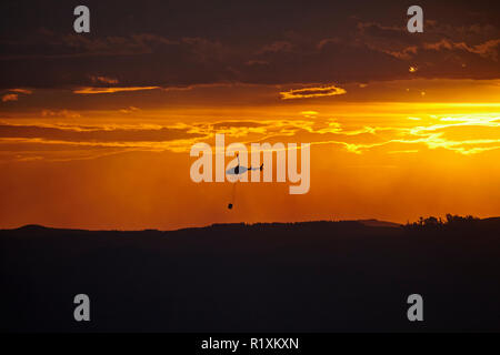 Smokey tramonto e elicottero antincendio a Burnside, Dunedin, Isola del Sud, Nuova Zelanda Foto Stock