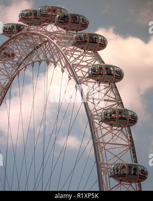 Chiusura del London Eye ruota panoramica Ferris baccelli contro un blu e il cielo nuvoloso. Foto Stock