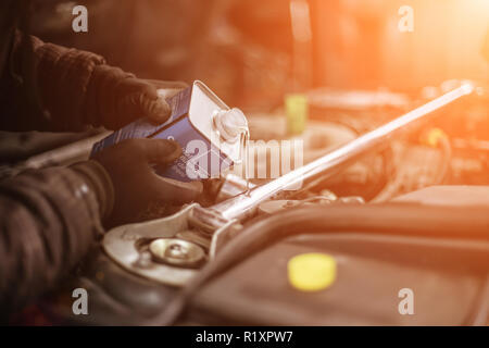 Freno DOT4 cambio del fluido in un auto da elegante bottiglia di metallo e i colori del tramonto Foto Stock