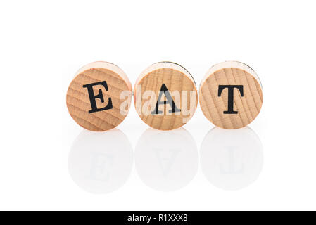 Parola mangiare da circolare piastrelle in legno con lettere giocattolo per bambini. Concetto di bambini calendario scritto in bambini toy lettere. Foto Stock