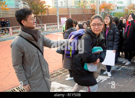 Busan, Seoul, Corea del Sud. 15 Nov 2018. Un insegnante (L) incoraggia un senior studente di scuola superiore arriva di fronte a un esame hall del collegio nazionale esame di entrata in Busan, circa 420 km (261 miglia) di sud-est di Seoul, Corea del Sud. La Corea del Sud ha tenuto la annuali nazionali di collegio ingresso esame, il collegio scolastico prova attitudinale (CSAT) Giovedì e circa 540.000 ricorrenti ha preso la prova per quest'anno. Credito: Lee Jae-Won/AFLO/Alamy Live News Foto Stock