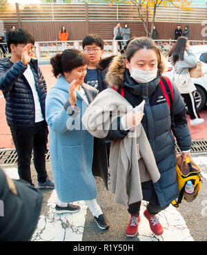 Busan, Seoul, Corea del Sud. 15 Nov 2018. Una madre (2 L) incoraggia la figlia (R), un senior high school student come quest'ultimo fratelli più giovani vedere la sua vita fuori di fronte a un esame hall del collegio nazionale esame di entrata in Busan, circa 420 km (261 miglia) di sud-est di Seoul, Corea del Sud. La Corea del Sud ha tenuto la annuali nazionali di collegio ingresso esame, il collegio scolastico prova attitudinale (CSAT) Giovedì e circa 540.000 ricorrenti ha preso la prova per quest'anno. Credito: Lee Jae-Won/AFLO/Alamy Live News Foto Stock