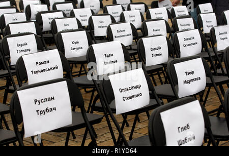 Sedie vuote con fogli allegati con nomi di ucraini di prigionieri politici in Russia, sono visti durante le prestazioni simbolico chiamato 'Free sedie sulla San Michele Square a Kiev. Il rally volti a sostenere il regista Oleg Sentsov e ucraino altri prigionieri politici in Russia, in Crimea e la zona di conflitto dell'est di ucraino. Una sedia vuota simboleggia un autore che non può essere presente su un particolare evento in un risultato di reclusione, detenzione, sparizione, un pericolo per la vita o di uccidere. Foto Stock