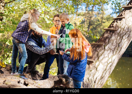 Curioso nice i bambini in piedi vicino al lago Foto Stock