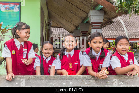 Studentesse indonesiano in uniforme in posa davanti la loro scuola Foto Stock