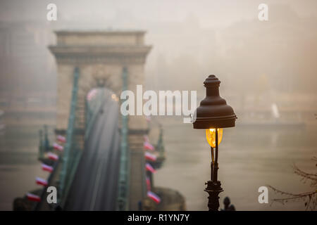 Budapest, Ungheria - Lampione con il famoso Ponte delle catene di Szechenyi a sfondo su una nebbiosa mattina di autunno Foto Stock