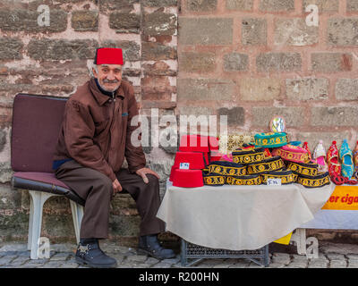 Istanbul, Turchia, Novembre 13, 2012: Turco uomo vendita cappelli turchi al di fuori del Museo Chora di Balat. Foto Stock