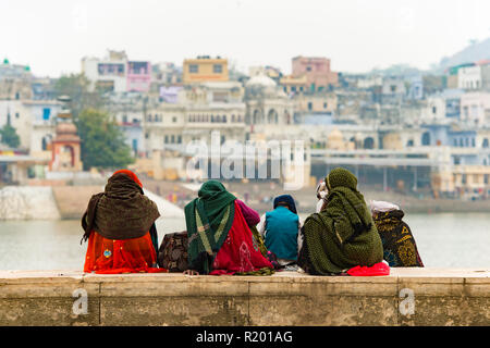 Hindu devoti pellegrini stanno godendo la vista di fronte del lago sacro (Sagar) sul ghats di Pushkar, Rajasthan. Foto Stock