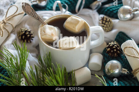 Una tazza di caffè e marshmallow nel nuovo anno la tavola del Natale impostazione su un sfondo lucido Foto Stock