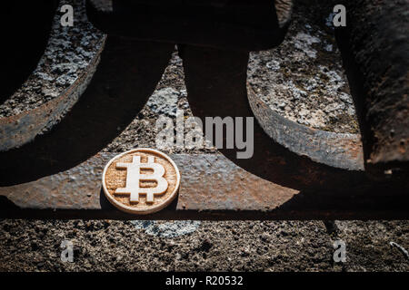 In legno chiaro di monete di bit su un rubare recinzione arrugginita con ombre. Foto Stock