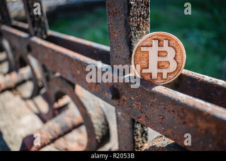 In legno chiaro di monete di bit su un rubare recinzione arrugginita con ombre. Foto Stock
