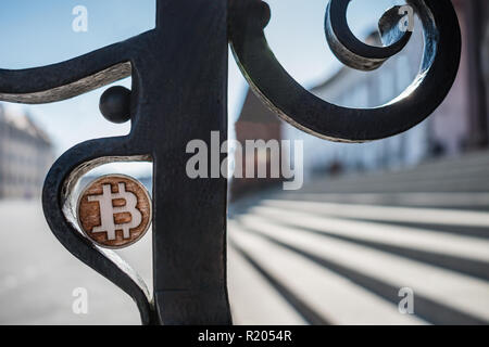 Bit di legno moneta su acciaio arrugginito antica recinzione in una giornata di sole. Foto Stock