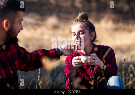Giovane gustando una tazza di caffè e cioccolato all'aperto Foto Stock
