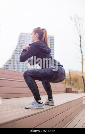 Donna Fitness jumping outdoor in ambiente urbano per giorno Foto Stock