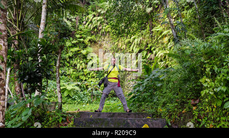 Un backpacker nella giungla accanto al fiume di Hawaii. Foto Stock