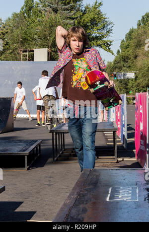 Il Kazakistan ALMATY - Agosto 28, 2016: Urban estrema concorrenza, dove la città gli atleti competere nelle discipline: skateboard, pattini a rotelle, BMX. Guidatore di skateboard facendo un trick in skate park Foto Stock