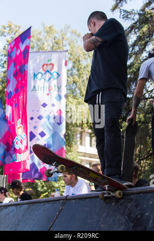 Il Kazakistan ALMATY - Agosto 28, 2016: Urban estrema concorrenza, dove la città gli atleti competere nelle discipline: skateboard, pattini a rotelle, BMX. Guidatore di skateboard facendo un trick in skate park Foto Stock