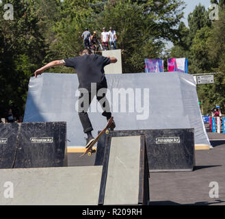 Il Kazakistan ALMATY - Agosto 28, 2016: Urban estrema concorrenza, dove la città gli atleti competere nelle discipline: skateboard, pattini a rotelle, BMX. Guidatore di skateboard facendo un trick in skate park Foto Stock